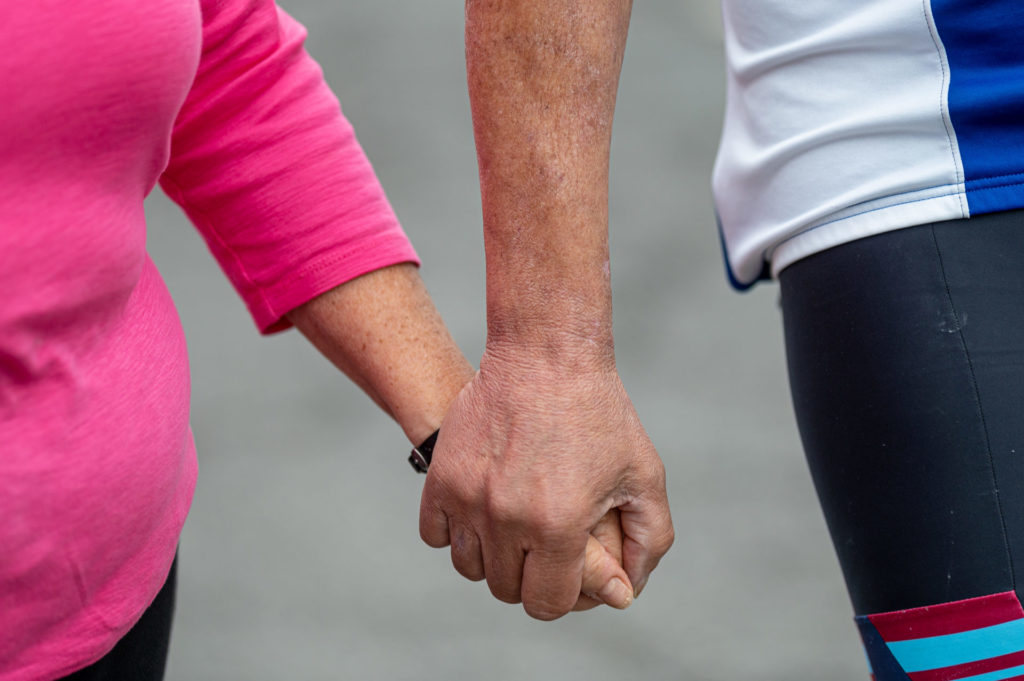 Close up of Jeff and wife holding hands whilst walking