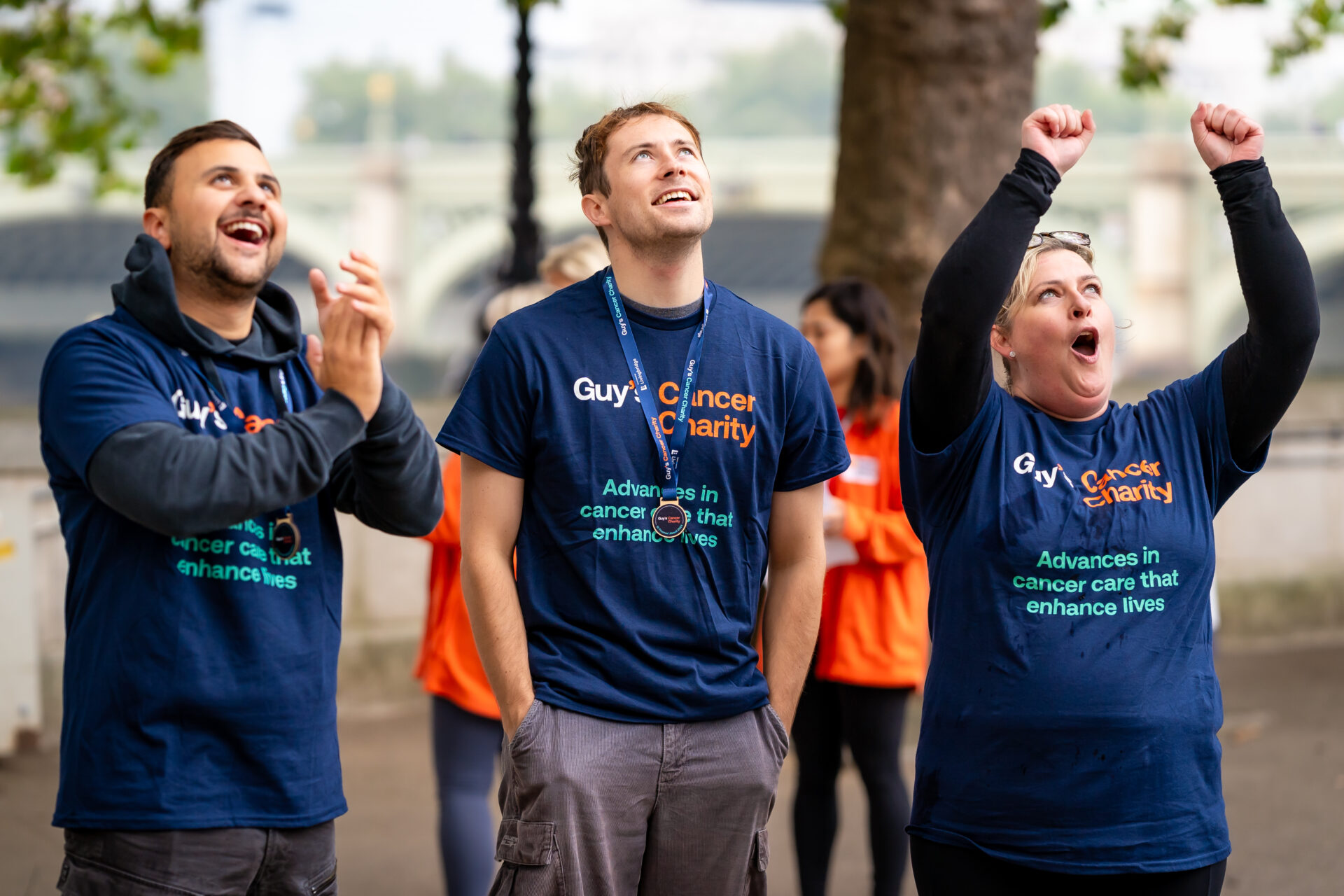 Image of three people cheering, wearing Guy