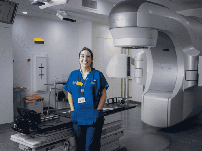 Nurse in front of the HyperArc machine she is in Guy